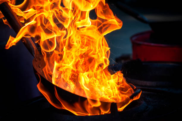istock Chef cooking with fire in frying pan 1202117595