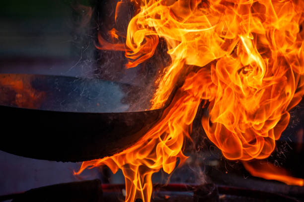 istock Chef cooking with fire in frying pan 1202117598