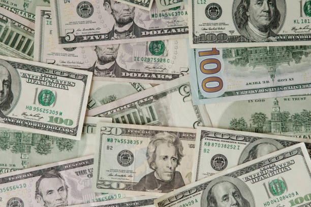 istock background from scattered dollar banknotes as abstract seamless. toned image 1202125420