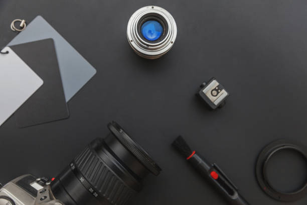 istock Photographer workplace with dslr camera system, camera cleaning kit, lens and camera accessory on dark black table background. Hobby travel photography concept Flat lay top view copy space 1202126844