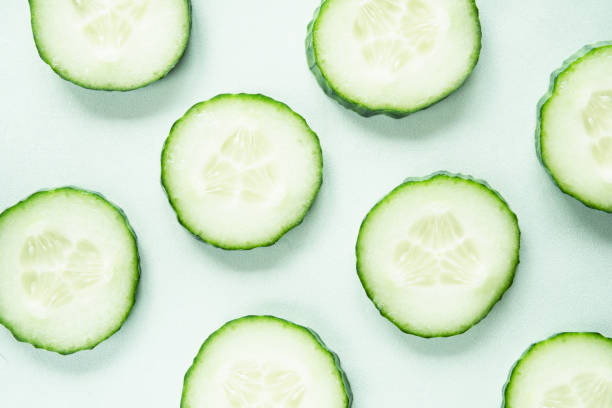 istock Pattern with freshly cut cucumber slices on green background 1202126891