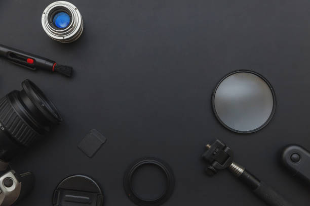 istock Photographer workplace with dslr camera system, camera cleaning kit, lens and camera accessory on dark black table background. Hobby travel photography concept. Flat lay top view copy space 1202126908