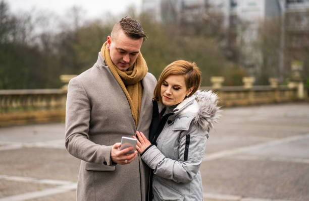 istock Young Couple Laughing at Something on Smartphone 1202128479