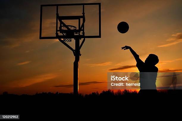 Backlit Silhouette Of A Teen Boy Shooting A Basketball Stock Photo - Download Image Now