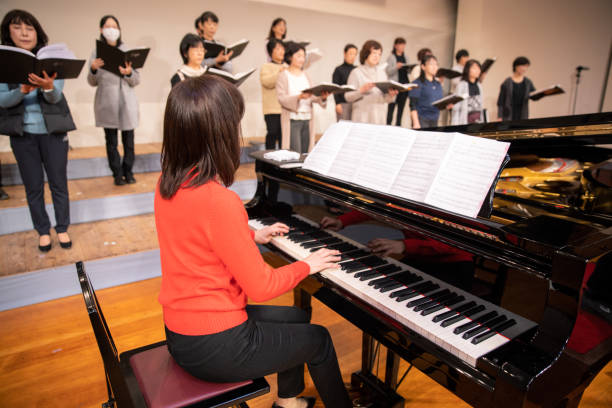 istock Woman playing the piano with women's chorus group 1202131824
