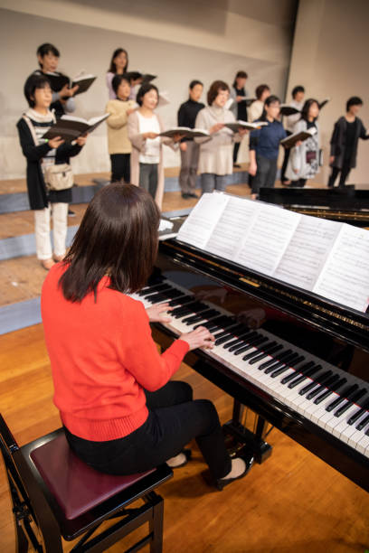 istock Woman playing the piano with women's chorus group 1202131857