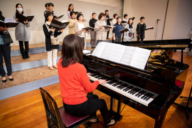 istock Woman playing the piano with women's chorus group 1202132369