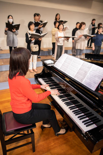 istock Woman playing the piano with women's chorus group 1202132444