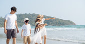 子供たちの幸せな休暇の概念とビーチで歩くアジアの家族