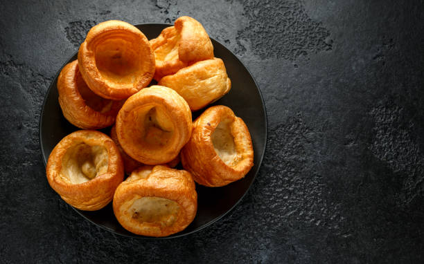 tradycyjny angielski yorkshire pudding danie boczne na czarnym talerzu i tle - yorkshire pudding zdjęcia i obrazy z banku zdjęć