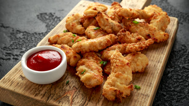 istock Buttermilk chicken nuggets with ketchup on wooden board 1202135125