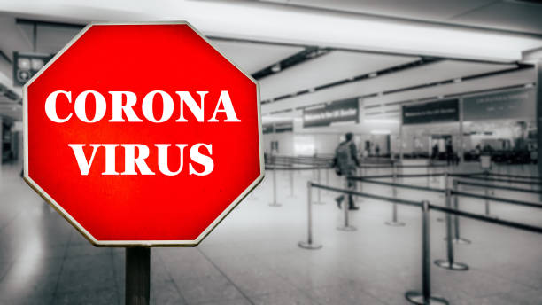 Coronavirus written on stop sign with passengers arriving at passport control within generic airport Coronavirus written on stop sign with passengers arriving at passport control within generic airport. The virus, which originated in China is quickly spreading around the world in early 2020 dystopia concept photos stock pictures, royalty-free photos & images