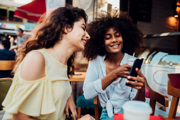 istock Two girls surfing the net at the cafe 1202138727