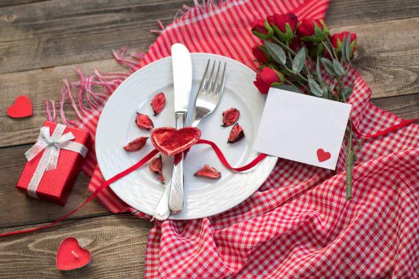 istock Romantic dinner concept.Valentines day greeting card. Red rose flowers, wine and gift box on wooden table. 1202139840