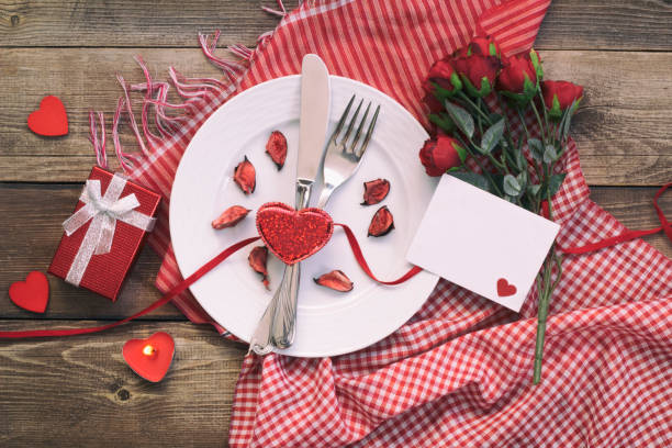 istock Romantic dinner concept.Valentines day greeting card. Red rose flowers, wine and gift box on wooden table. 1202139841