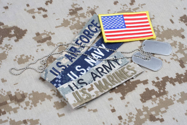 US MILITARY concept with branch tapes and dog tags on camouflage uniform US MILITARY concept with branch tapes and dog tags on camouflage uniform background us military stock pictures, royalty-free photos & images