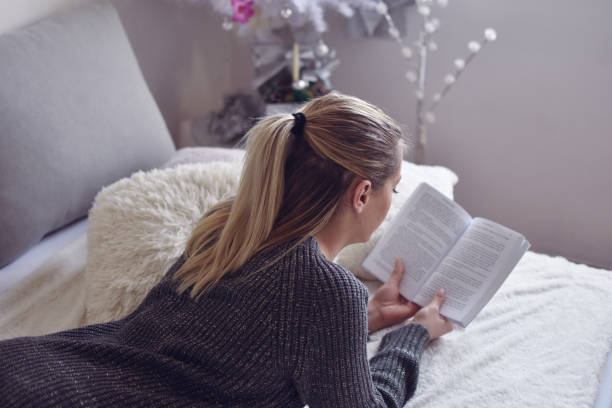 istock Relaxed woman reading a book in her bed 1202140939