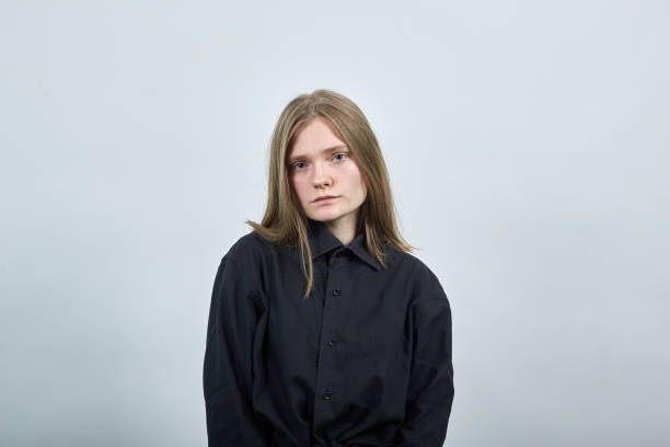 istock Disappointed young woman on gray wall in studio looking at camera, unhappy. 1202140972