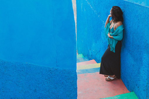 Woman by rainbow stairs in a small town in Morocco