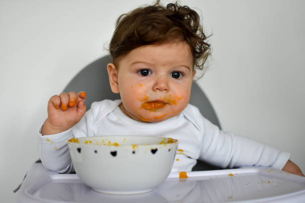 istock A Little baby eating her dinner and making a mess 1202143964