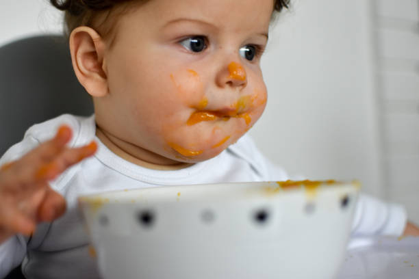 istock A Little baby eating her dinner and making a mess 1202144591