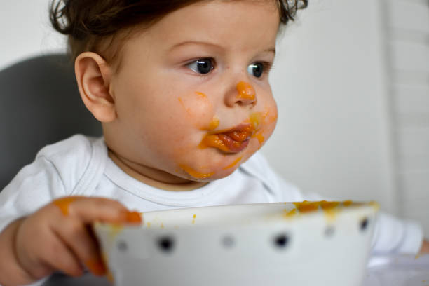 istock A Little baby eating her dinner and making a mess 1202144647