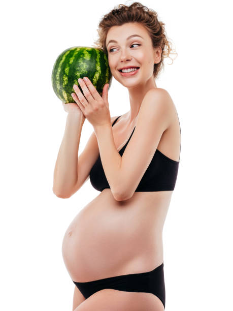 istock Pregnant woman holding a watermelon 1202144897