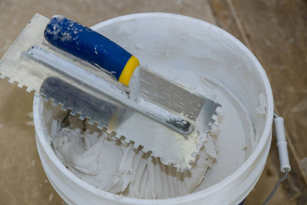 istock Trowel mortar tIling a closeup with trowel ceramic tiles. 1202145153