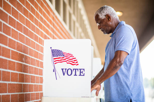 idoso homem negro votando em booth - election day - fotografias e filmes do acervo