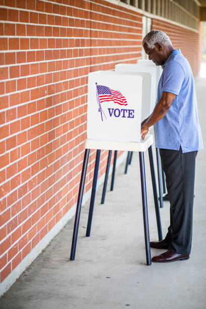 istock Senior Black Man Voting at Booth 1202146527