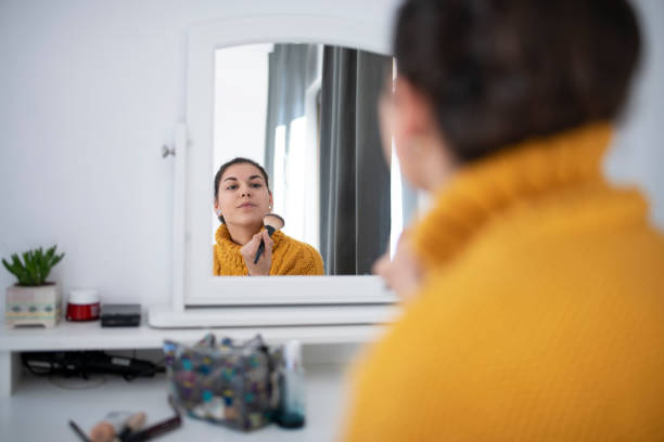istock Young Latino Woman Applying Makeup 1202151783