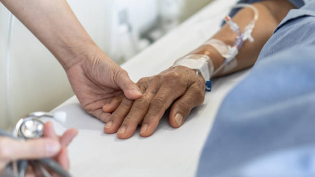Elderly senior aged patient on bed with geriatric doctor holding hands for trust and nursing health care, medical treatment, caregiver and in-patient ward healthcare in hospital Elderly senior aged patient on bed with geriatric doctor holding hands for trust and nursing health care, medical treatment, caregiver and in-patient ward healthcare in hospital inpatient stock pictures, royalty-free photos & images