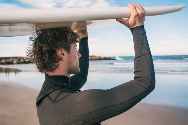 istock Young surfer holding up his surfboard. 1202154548