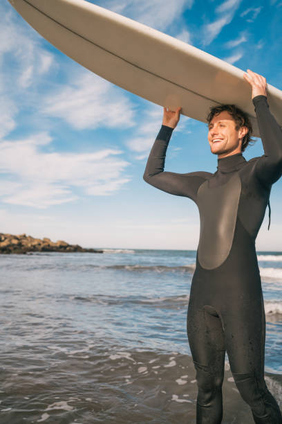 istock Young surfer holding up his surfboard. 1202154565
