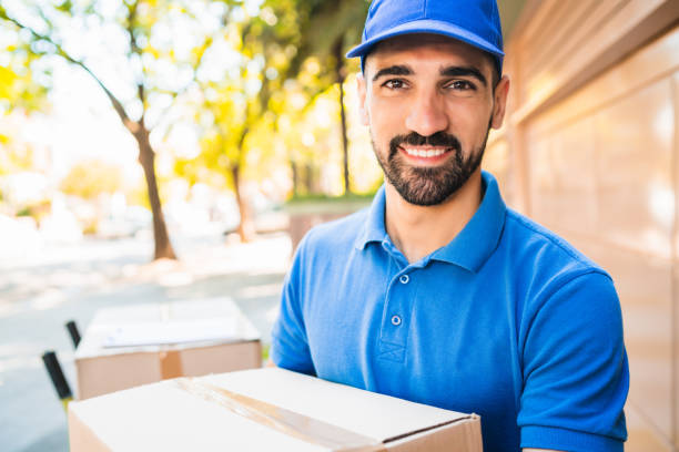 istock Delivery man carrying package outdoors. 1202154596