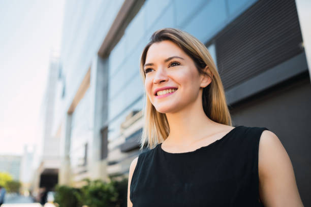 istock Business woman standing outside office buildings. 1202155008