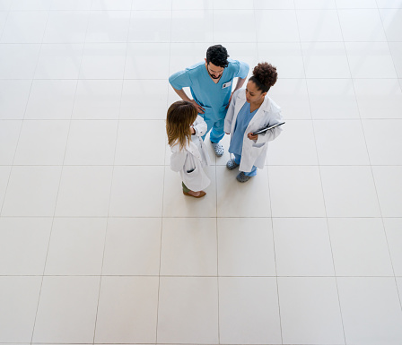 Multi ethnic team of healthcare professionals discussing something at the hospital grounds - High angle view