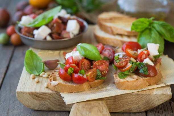istock Bruschetta with tomatoes, mozzarella cheese and basil on a cutting board. Traditional italian appetizer or snack, antipasto. Top view with copy space. Flat lay 1202156050