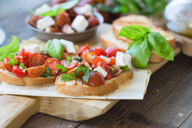 istock Bruschetta with tomatoes, mozzarella cheese and basil on a cutting board. Traditional italian appetizer or snack, antipasto. Top view with copy space. Flat lay 1202156051