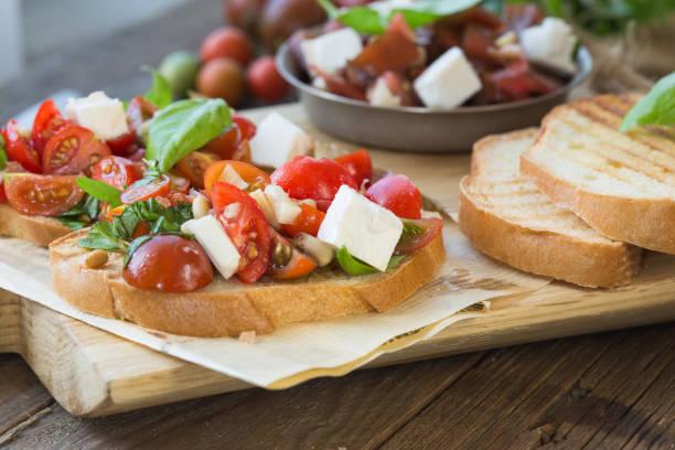 istock Bruschetta with tomatoes, mozzarella cheese and basil on a cutting board. Traditional italian appetizer or snack, antipasto. Top view with copy space. Flat lay 1202156052