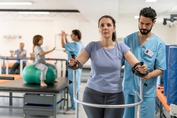 istock Male therapist walking behind female patient using a mobility walker during physical therapy 1202157466