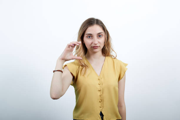 istock Charming young woman showing space between fingers, lookin directly 1202159701