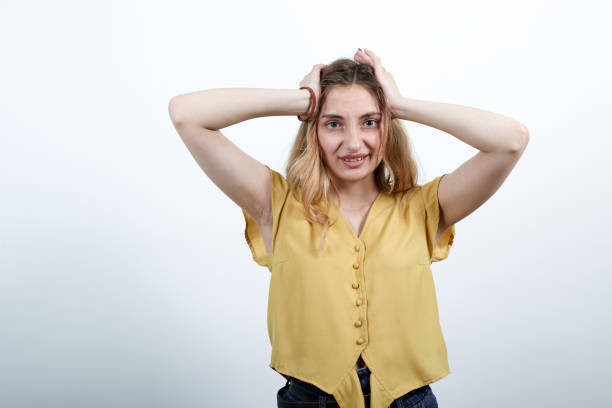 istock Cheerful woman keeping hand on head, smiling isolated on white wall. 1202169577