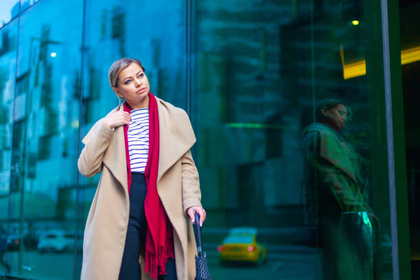 見事なブルネットの女の子のアウトドアライフスタイルファッションの肖像画。街の通りを歩く。買い物に行く。●スタイリッシュな白いフィットコート、赤いネックスカーフ、ブラックの� - neckscarf ストックフォトと画像