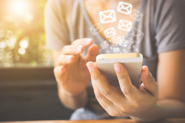 istock Close-up image of female hands using smartphone with icon envelope email. Contact us customer service or e-mail marketing concept 1202173931