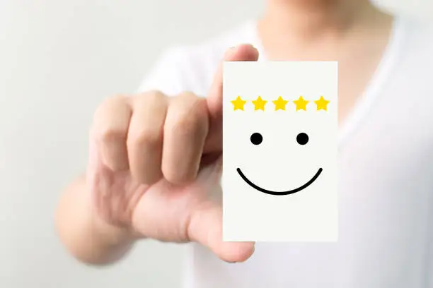 Photo of Customer service experience and business satisfaction survey. Man holding card with smiley face with five star