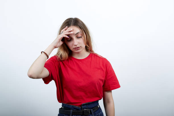 istock Tired woman keeping hand on forehead, having headache, looking down 1202174077
