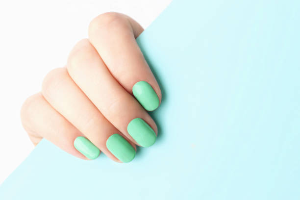 istock Female hand with trendy manicure Neo-mint on blue background with copy space 1202178012
