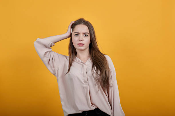 istock Happy young woman keeping hand on head, having headache, looking at camera 1202181027