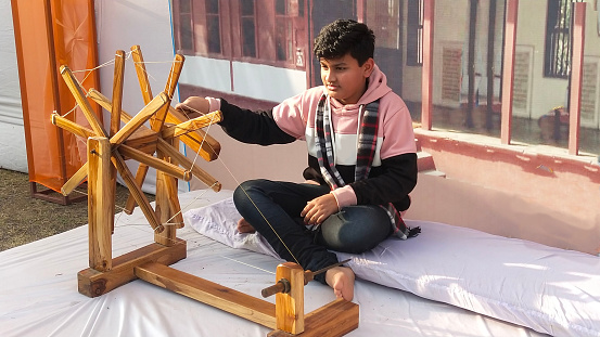 This boy in India is winding yarn on an antique yarn winder.  This nostalgic tool gives him hands-on experience seeing how such simple tasks were done years ago.